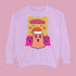 A holiday sweatshirt featuring a cute ghost character wearing a Santa hat, with two smaller ghosts on either side. Above them is the playful text "Boo Humbug," surrounded by snowflakes and festive elements. The design humorously combines spooky and festive themes for a unique holiday look.